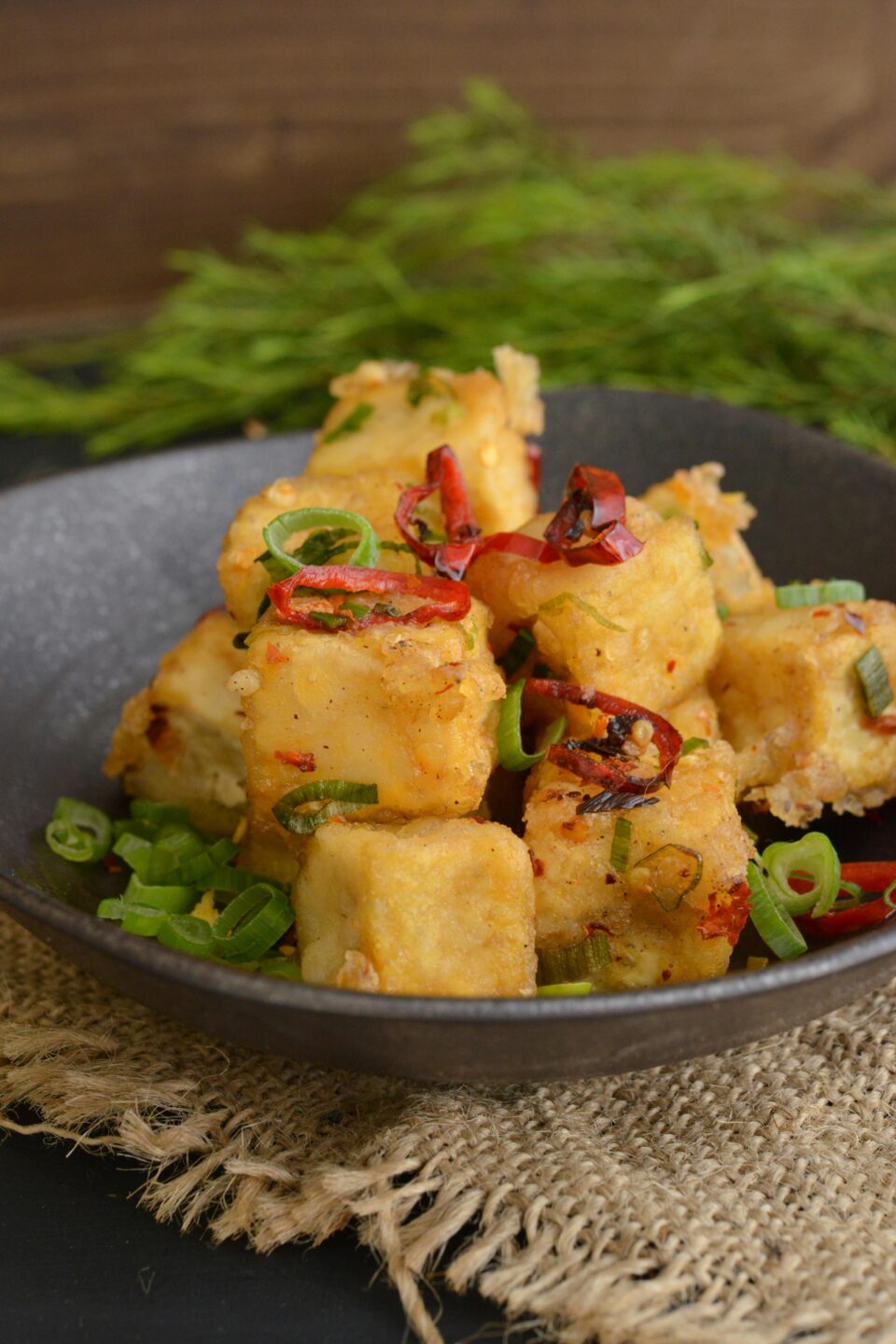 Tofu fritto piccante con peperoncino e cipollotto, un piatto veg-friendly ispirato alla cucina tailandese, perfetto per un viaggio culinario in Thailandia.