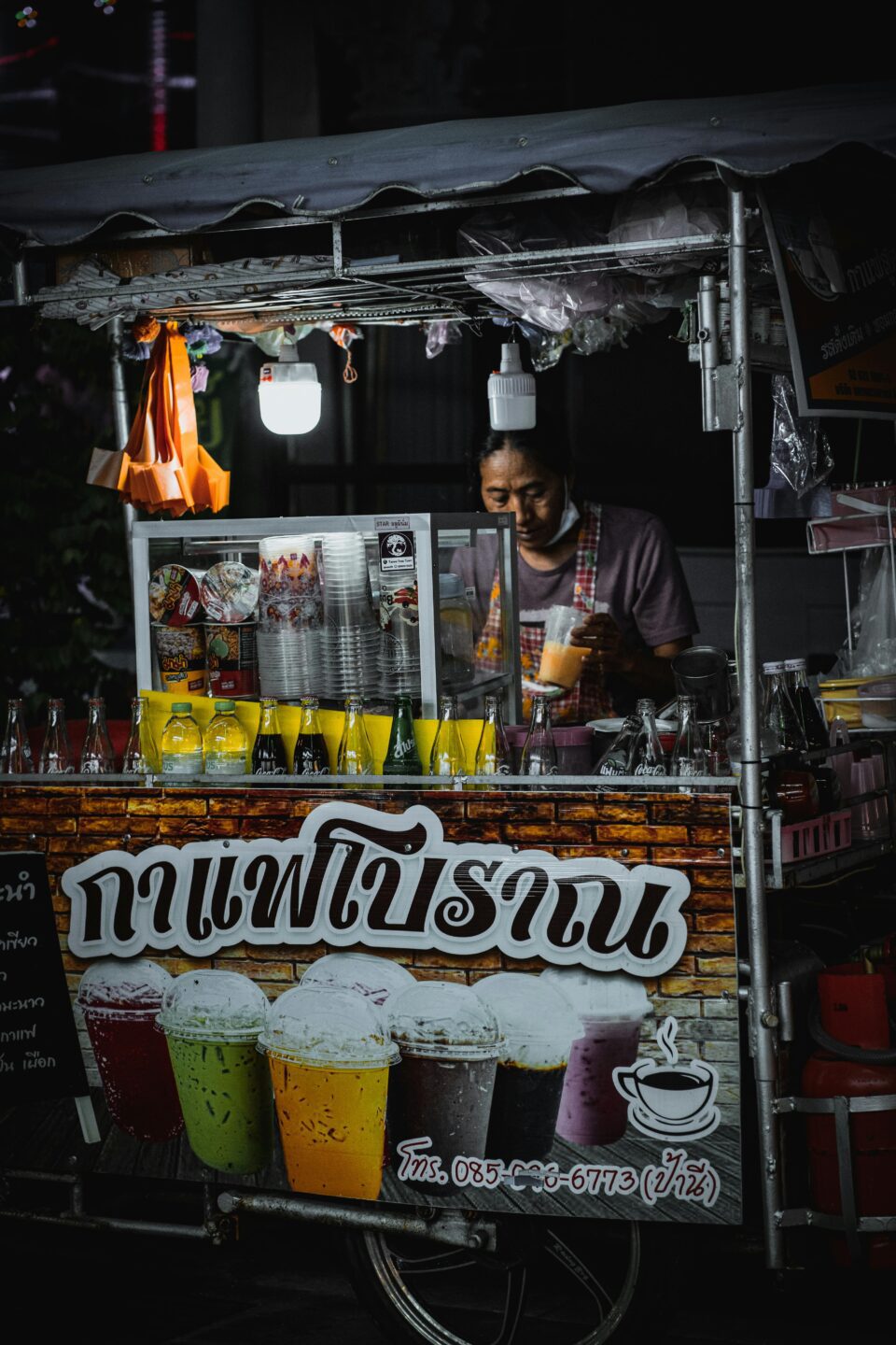 Bancarella di street food a Bangkok che serve bevande colorate e rinfrescanti, un'opzione perfetta per esplorare la scena veg-friendly nei mercati thailandesi.