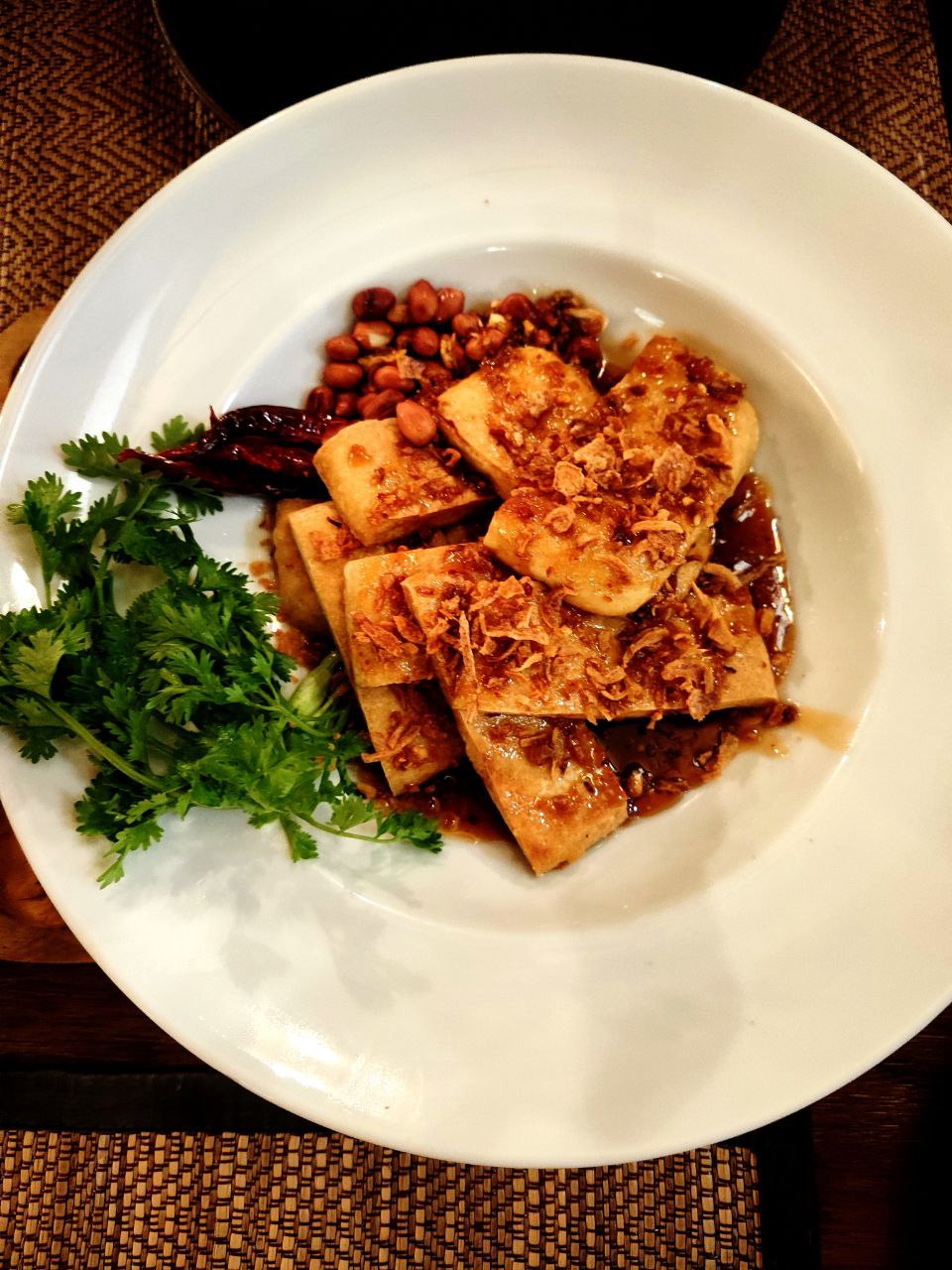 Tofu al tamarindo servito con arachidi, coriandolo e cipolla croccante al Green Tiger House di Chiang Mai, un piatto vegetale dal sapore agrodolce tipico della cucina veg-friendly locale.